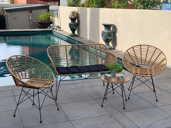 Outdoor patio setting Isla with bench seat, made from plastic/PU simulated cane, in natural cane finish. Pictured in a pool setting.