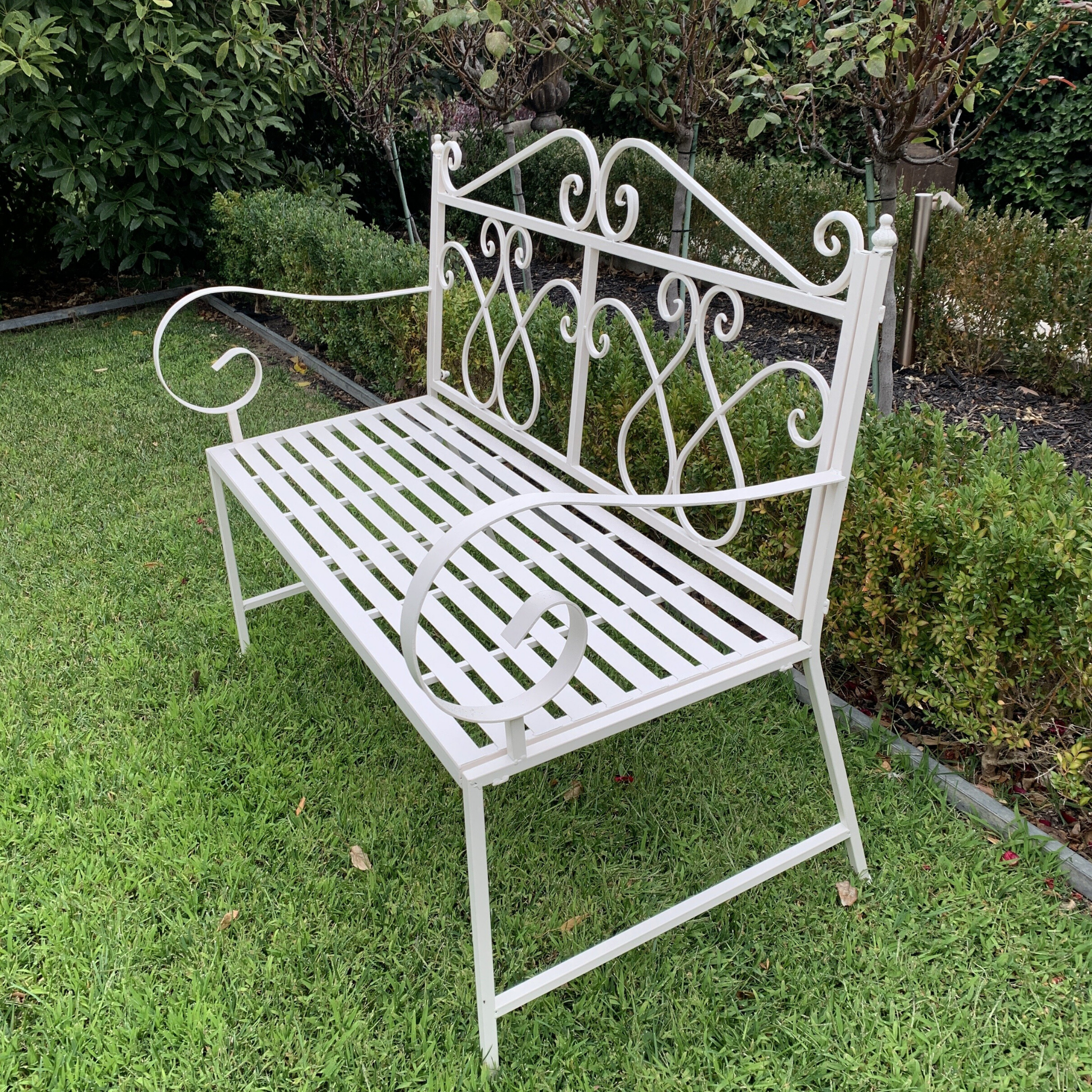 Outdoor garden bench seat Zara, made from metal, in cream colour, pictured in garden setting