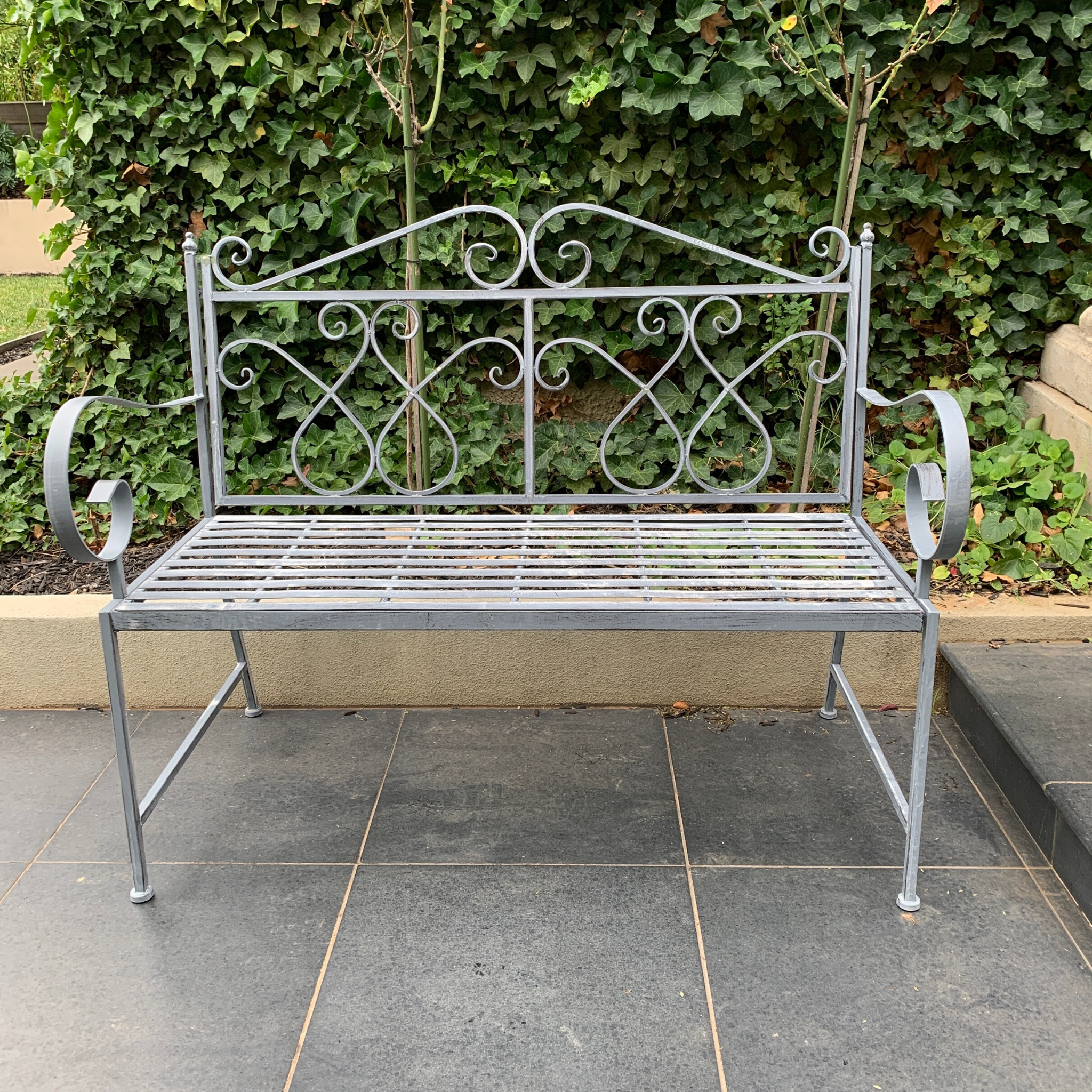 Outdoor garden bench Zara, made from metal, in grey with white wash colour, pictured in garden setting