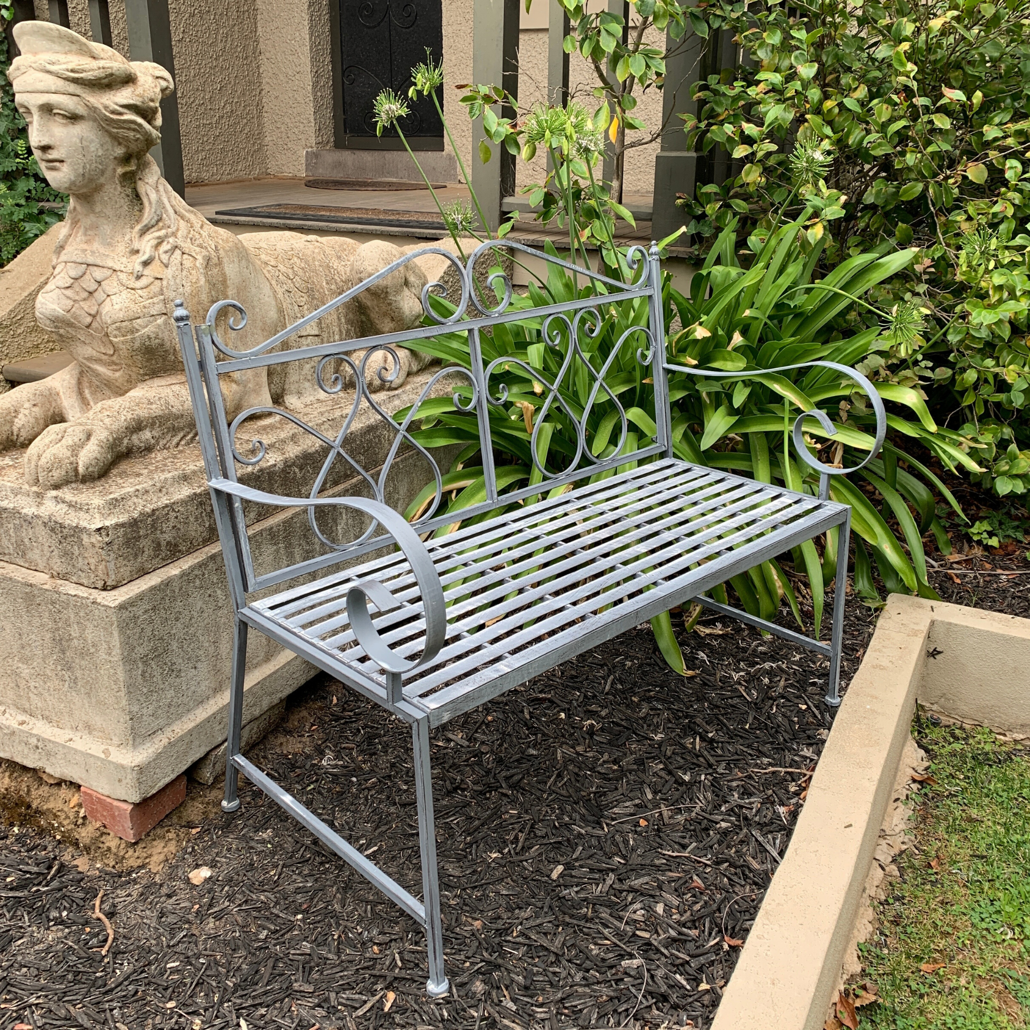 Outdoor garden bench Zara, made from metal, in grey with white wash colour, pictured in garden setting side view