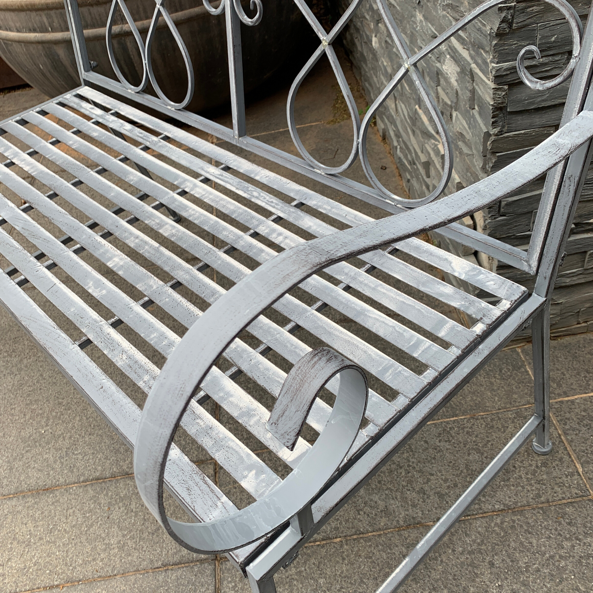 Outdoor garden bench Zara, made from metal, in grey with white wash colour, pictured close up of arm & seat