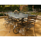 Outdoor Dining setting made from natural stone- Granite, 6 wrought iron dining chairs- Dinner chair style and solid iron table base. Pictured in a courtyard, garden setting.