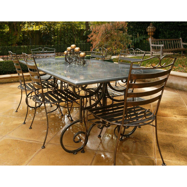Outdoor Dining setting made from natural stone- Granite, 6 wrought iron dining chairs- Dinner chair style and solid iron table base. Pictured in a courtyard, garden setting.